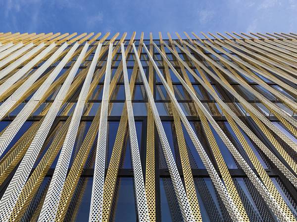 A building facade wall designed with aluminum perforated angles.