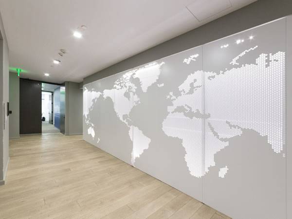 Interior perforated metal wall designed with a map of the world.