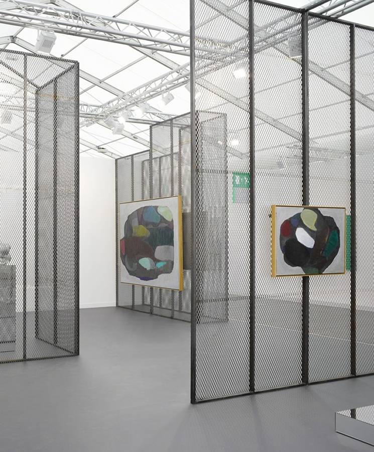 Black expanded metal panels are used as room divider of the art gallery.