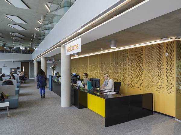 Yellow partition wall is designed with CNC perforated panels.