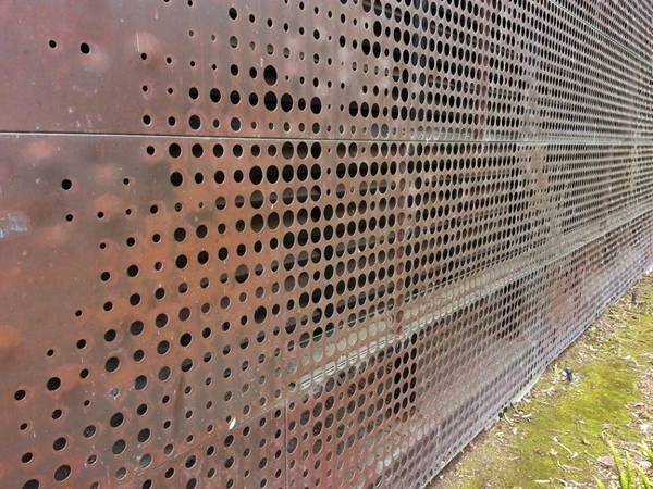 A embossed building cladding wall designed with perforated copper panels.