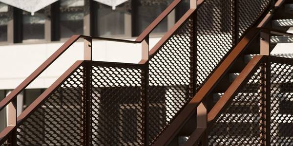 Outdoor stairway is infilled with copper plated expanded metal sheets.