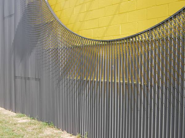 A building facade wall designed with corrugated perforated panels.