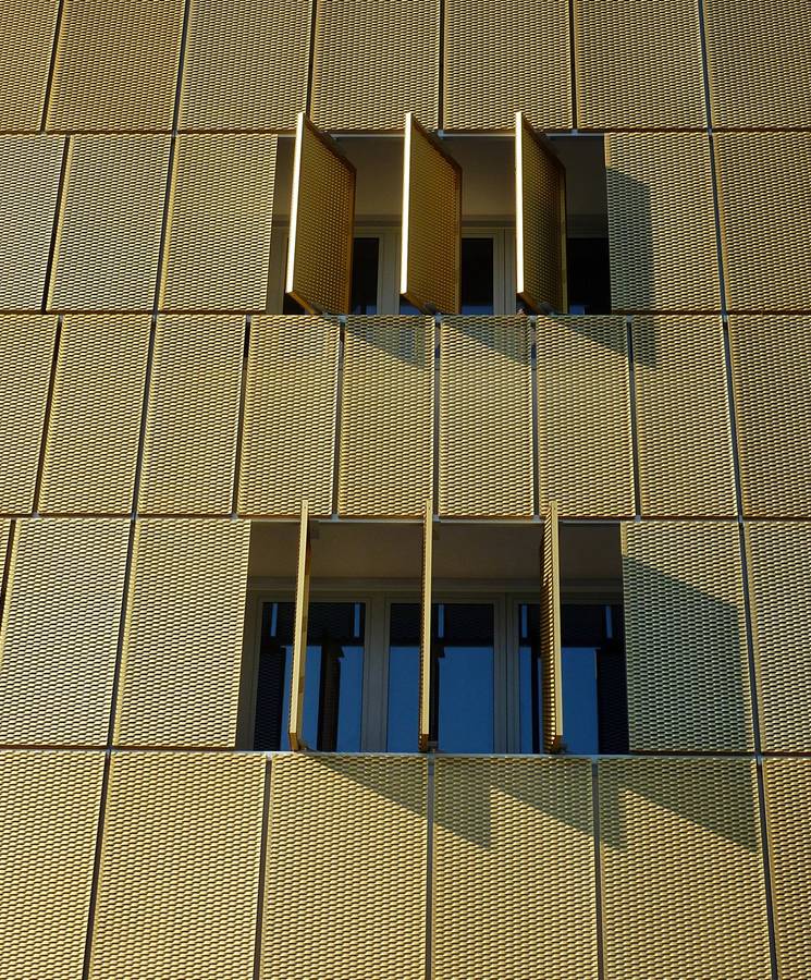 Golden architectural sunshades designed with expanded metal sheets.
