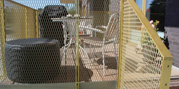 The balustrade of this balcony is infilled with golden plated expanded metal sheets.