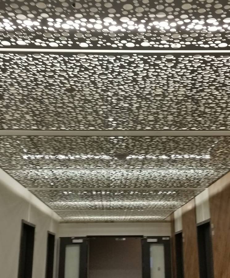 The ceiling of the passageway is decorated with round perforated metal panels.