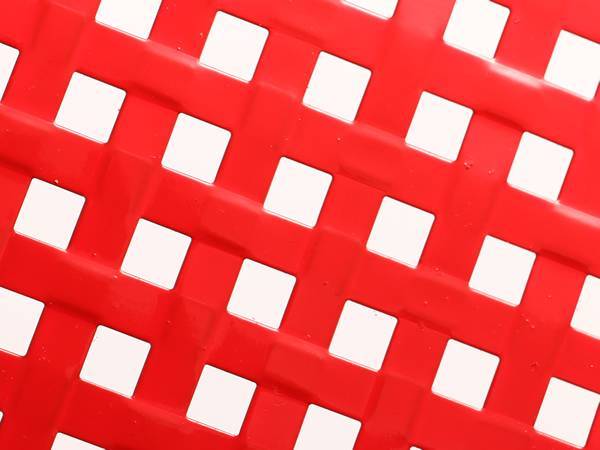 Red perforated steel sheet with square holes.