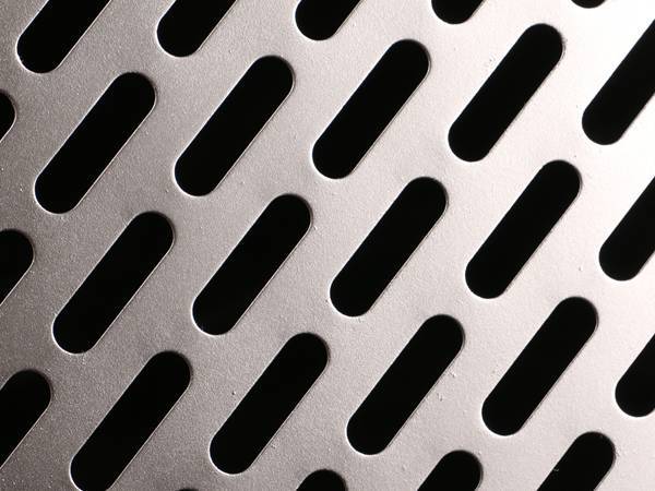 Perforated galvanized steel sheet with oblong round holes.