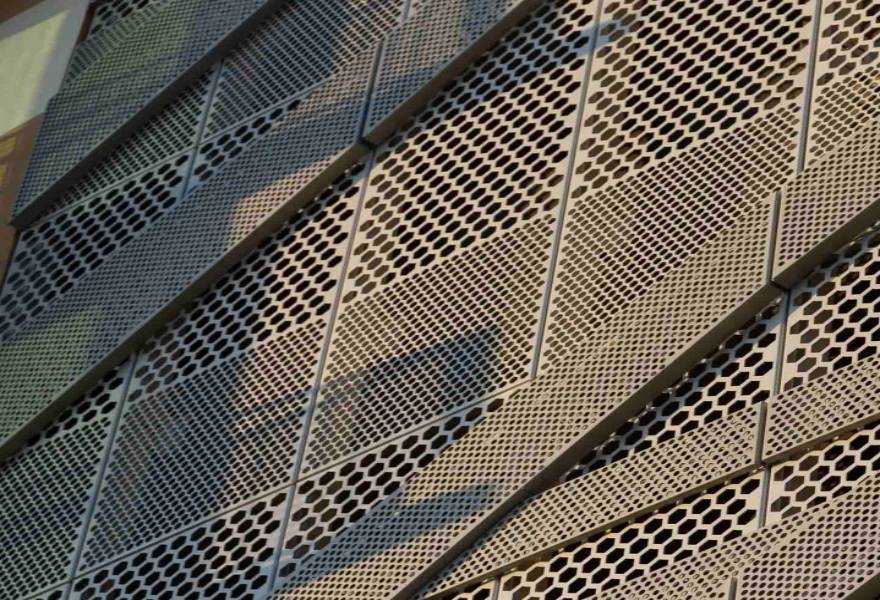 Different holes types of perforated metal sheets are installed on the building facade.