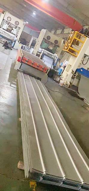 A roller forming machine is pressing the Perforated Corrugated Sheet