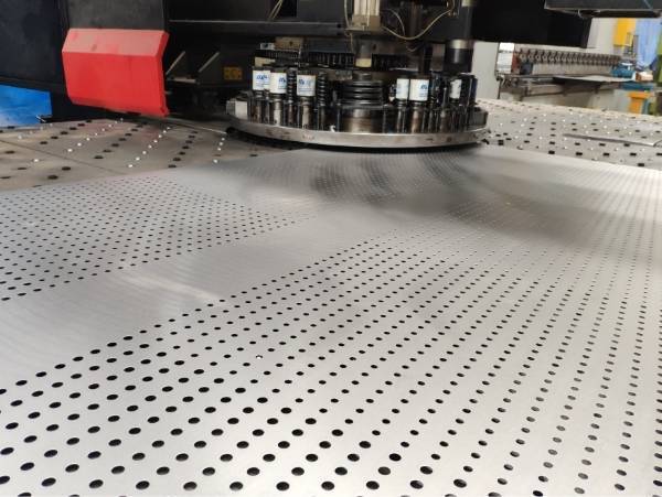 A machine is producing perforated metal sheet.