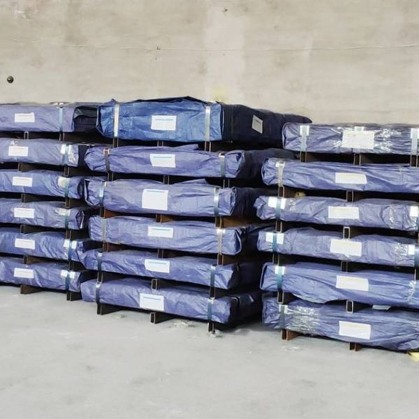 Several pallets of perforated steel sheets in the warehouse.