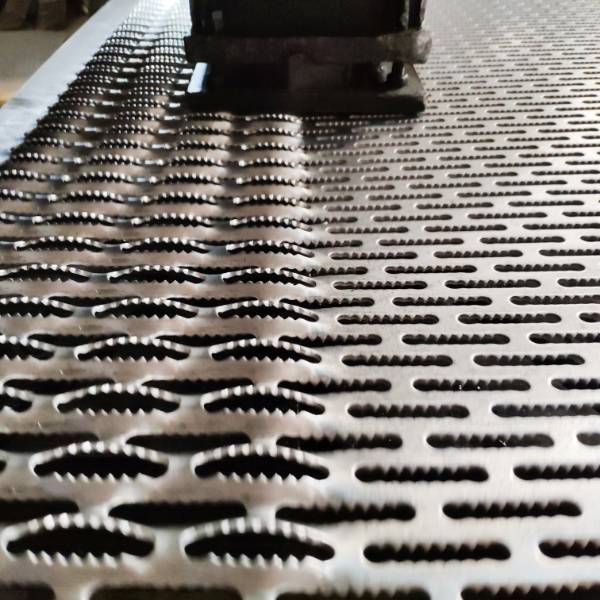 A CNC Punching & Pressing machine is producing grip-strut safety grating.