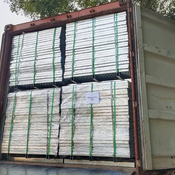 Several pallets of perforated metal sheets in the container.