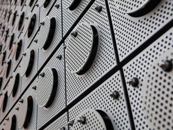 A embossed building cladding wall designed with perforated steel profiles.
