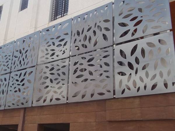 Perforated stainless steel sheets with oval holes for facade wall design.