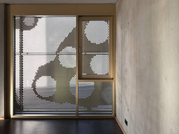 The French window is decorated with perforated stainless steel sheets.