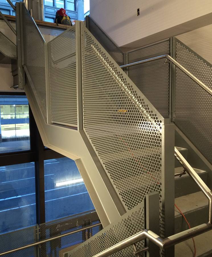 Stainless steel perforated metal panels for staircase handrail.