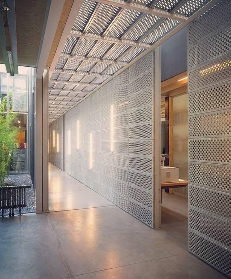 Lobby interior wall designed with round hole perforated metal sheets.