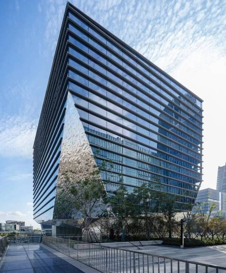 The facade at the entrance of office building is decorated with water ripple sheets.